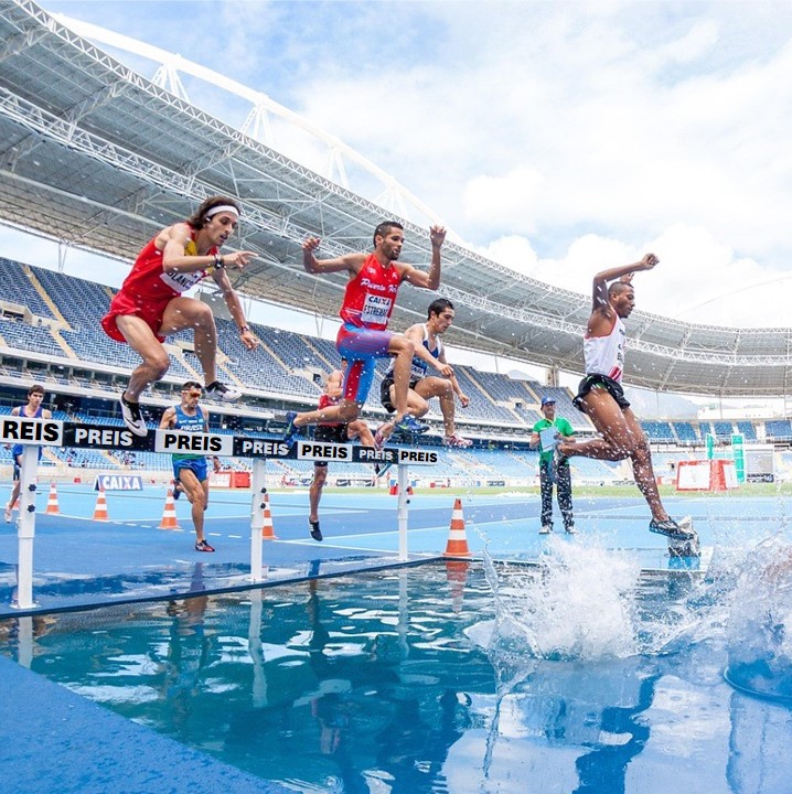 Stadion mit Sportlern beim Hindernislauf und Wassergraben